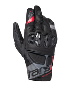 Alpinestars Belize V3 Drystar Gloves, short-cuff adventure motorcycle gloves, black with red and gray accents, featuring hard knuckle protection with a hexagonal pattern, perforated leather panels, and "ADVENTURE" branding on the wrist.