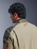 Alpinestars Nazca 3L GORE-TEX PRO Jacket, Walnut Rock Brown adventure jacket, close-up of the back and shoulder, red star logo on the neck, grey textured reinforcement panels, durable textile construction for motorcycle riding