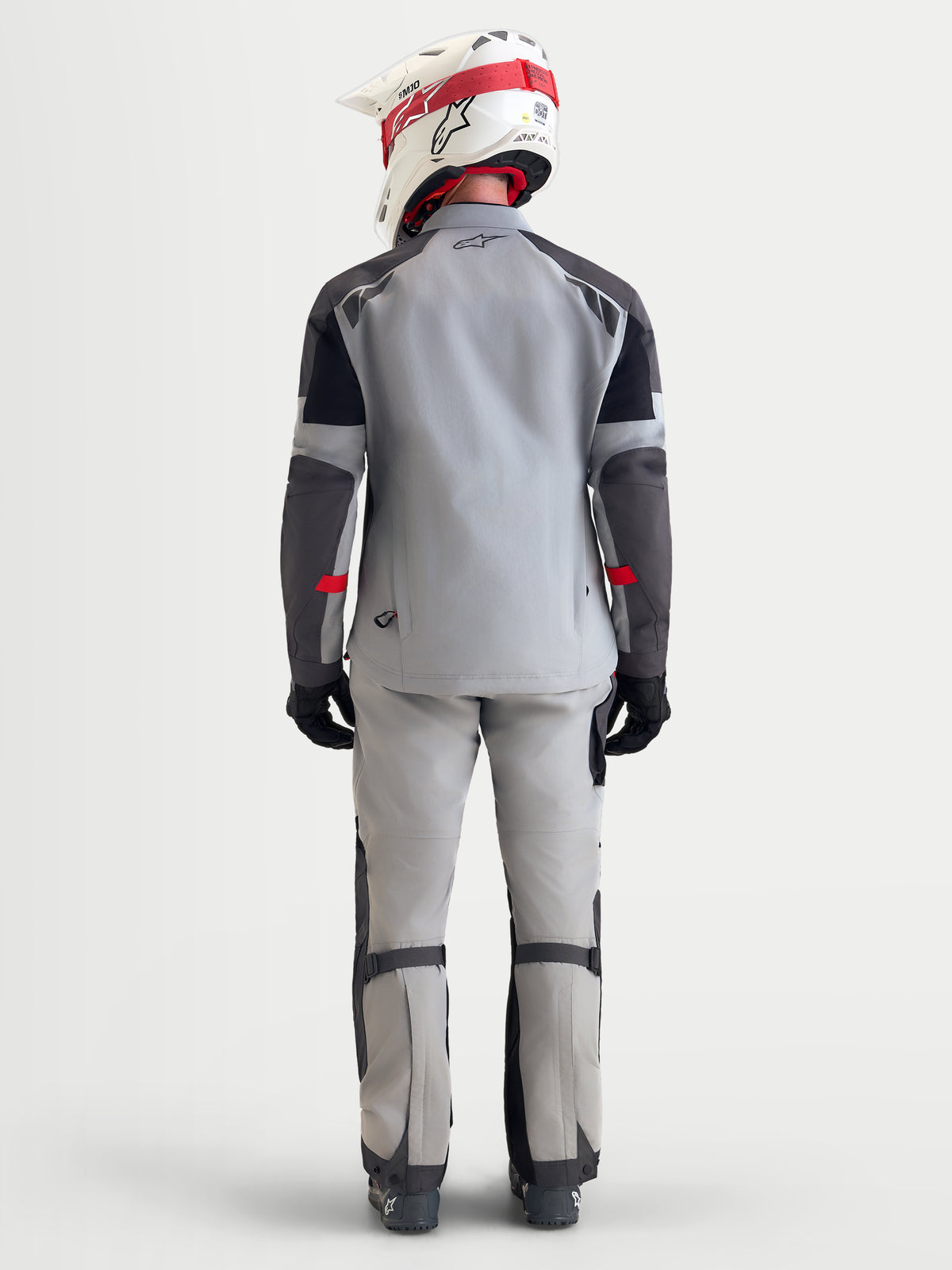 Alpinestars Arenis Gore-Tex Gear Set, men's adventure touring motorcycle jacket and pants in light gray, dark gray, and black, rear view on a model wearing a matching helmet and riding gear.