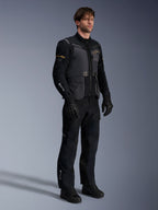 Male model wearing the Alpinestars ST-7 2L GORE-TEX Jacket in Deep Gray Black and Dark Khaki, paired with matching black adventure pants and gloves, featuring waterproof laminated shell with cargo pockets and technical branding, ideal for adventure touring.