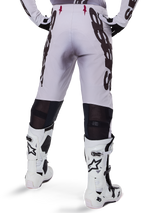 Alpinestars 2025 Supertech Maker Pants, Motocross Pants, Silver and Black, back view showing large black logos on thighs and breathable mesh zones behind the knees, worn with white Alpinestars boots.