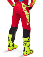 Alpinestars 2025 Supertech Maker Pants, Motocross Pants, Bright Red and Yellow Fluo, rear view, featuring bold yellow branding, black panels behind the knees, worn with matching fluo yellow boots, designed for pro-level off-road performance.