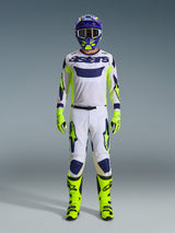 Alpinestars 2026 Racer Air Riway Pants, Motocross Pants, Light Gray with Yellow Fluo and Blue, worn by a rider in a full racing kit including matching white jersey, fluorescent yellow boots and gloves, and a blue helmet, professional off-road racing gear