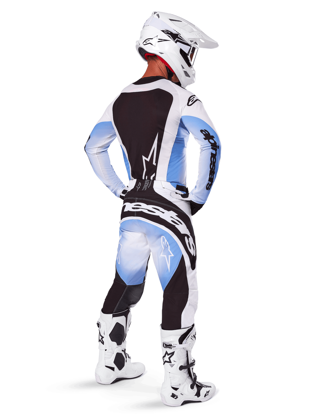 Motocross rider seen from behind wearing Alpinestars 2025 Techstar Melt Pants and jersey, Black Blue and White gradient design, white helmet, white and black boots, full off-road racing kit.
