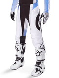 Alpinestars 2025 Techstar Melt Pants, Motocross Pants, White and Black with Blue accents, featuring laser-cut perforations for airflow and Babel knee construction, worn with matching white motocross boots and gloves, athletic off-road racing design