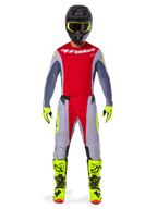 Motocross rider wearing the Alpinestars 2025 Techstar Melt Gear Set in Bright Red Gray, featuring a red jersey with gray sleeves, gray pants with red and fluorescent yellow accents, coordinated neon yellow boots and gloves, and a black helmet with neon yellow goggles.