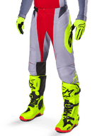 Alpinestars 2025 Techstar Melt Pants, Motocross Pants, Bright Red and Gray, featuring neon yellow side graphics and black knee panels, paired with matching neon yellow boots and gloves, designed for competitive off-road performance