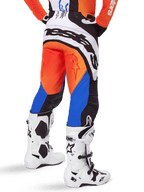 Alpinestars 2025 Techstar Melt Pants, Motocross Pants, Orange and Blue, viewed from behind, featuring large white branding on the seat, worn with matching orange jersey and white Tech 10 boots, durable off-road racing gear