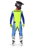 Alpinestars 2025 Techstar Melt Pants, Motocross Pants, Yellow Fluo Blue, worn with matching jersey, yellow gloves, and white and black boots, featuring a black helmet with red goggles, complete racing gear set for off-road performance