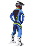Alpinestars 2025 Techstar Melt Pants, Motocross Gear, Yellow Fluo Blue, rear view of rider wearing matching blue jersey with large yellow branding, white and black boots, and black helmet, coordinated racing outfit for off-road performance
