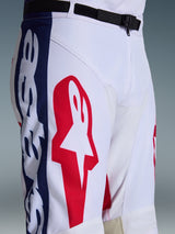Alpinestars 2026 Racer Riway Pants, Motocross Pants, White Blue Red, close-up of the upper leg and waist showing large red star logo on white polyfabric, blue side panels with branding, and black adjustable waist belt with SX2 magnetic buckle, sporty off-road racing design