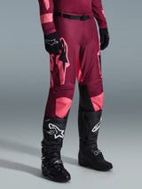 Alpinestars 2026 Racer Riway Pants, Motocross Pants, Dark Red Coral, featuring large pink star logos and black inner knee panels, worn with black motocross boots and black gloves, athletic race fit for off-road riding