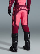 Alpinestars 2026 Racer Riway Pants, Motocross Pants, Dark Red and Coral, rear view showing large coral 'astars' branding on the seat, worn with black motocross boots and gloves, performance gear for off-road racing
