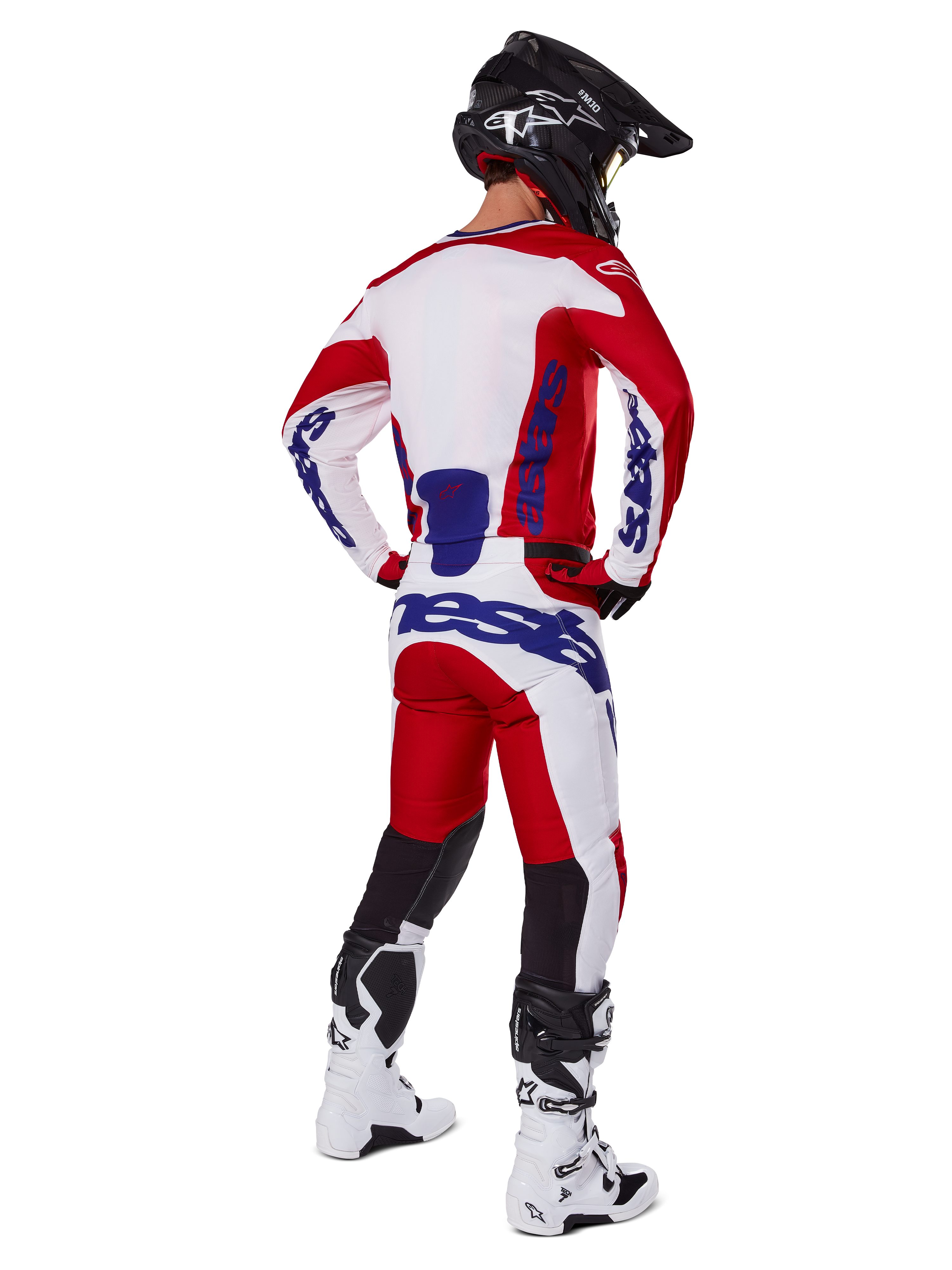 Alpinestars 2025 Racer Veil Pants, Motocross Pants, Bright Red and White with blue accents, shown from behind on a rider in full gear, featuring bold Alpinestars branding, breathable panels on lower legs, and coordinated white boots and black helmet.
