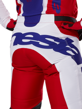Alpinestars 2025 Racer Veil Pants, Motocross Pants, Bright Red and White with blue branding, back view detail of seat area featuring a large Alpinestars logo, worn as part of a coordinated off-road racing outfit