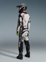 Motocross rider wearing the Alpinestars 2026 Racer Lahnd Pants in Sand Camo and Gray, full racing gear set with matching jersey, black helmet, and black boots, rear view highlighting the bold branding and ergonomic design.