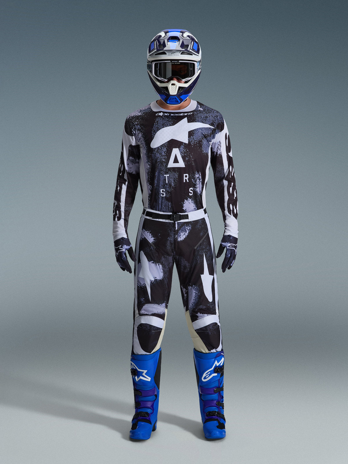 Alpinestars 2026 Racer Lahnd Gear Set, Motocross Outfit, Black and White with Iron Camo abstract pattern, paired with blue and white helmet and bright blue boots, complete racing kit for off-road performance