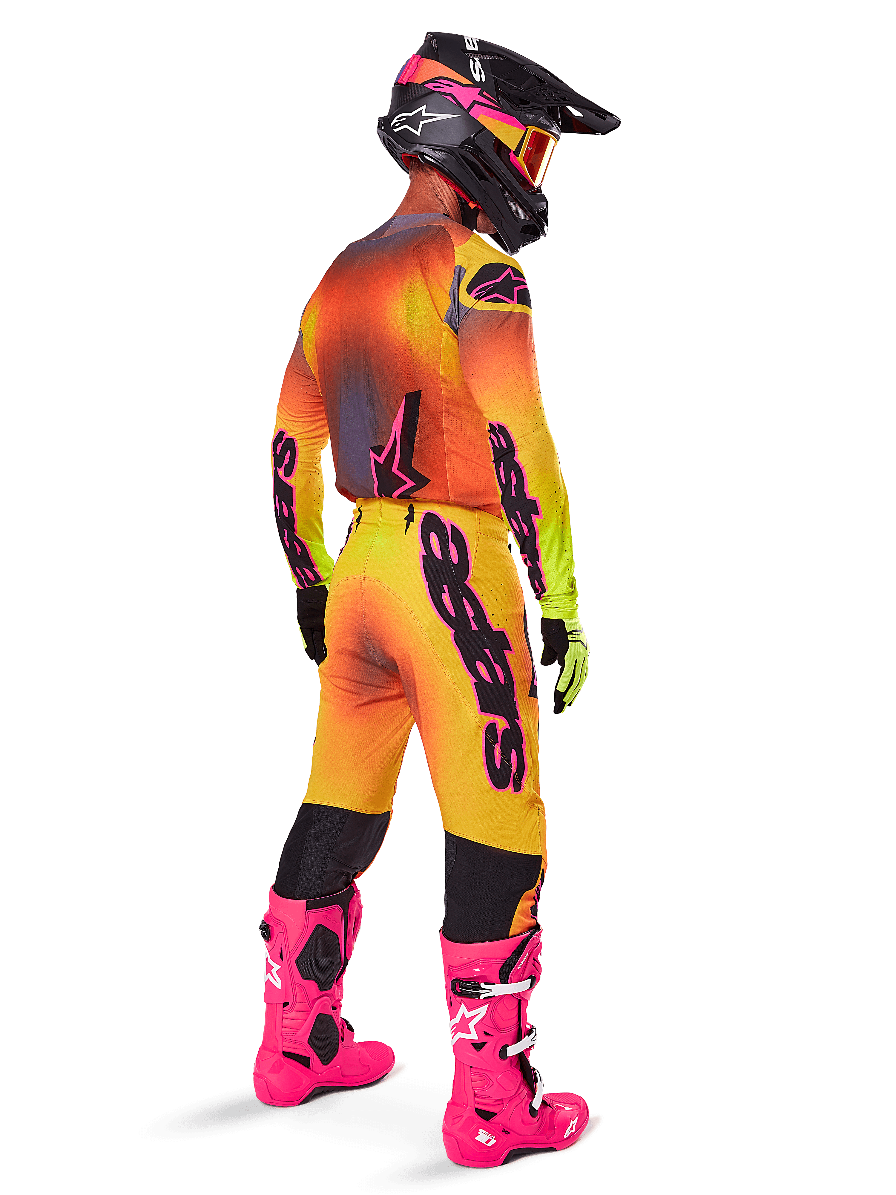 Motocross rider from a rear view wearing Alpinestars 2025 Supertech Lipan Pants, Yellow and Pink gradient, styled with matching jersey, bright pink boots, and a black helmet with pink accents, professional coordinated outfit for off-road racing.