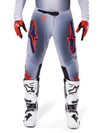 Alpinestars 2025 Supertech Lipan Pants, Motocross Pants, Gray and Orange Fluo, worn with red and black gloves and white and black boots, featuring large Alpinestars star logos on the thighs and ventilation perforations for pro-level racing.
