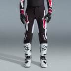Alpinestars 2026 Supertech AFD Vista Gear Set, Motocross rider wearing black pants with large white and red logos, matching performance jersey with burgundy cuffs, black gloves, and white professional racing boots, high-performance off-road racing outfit