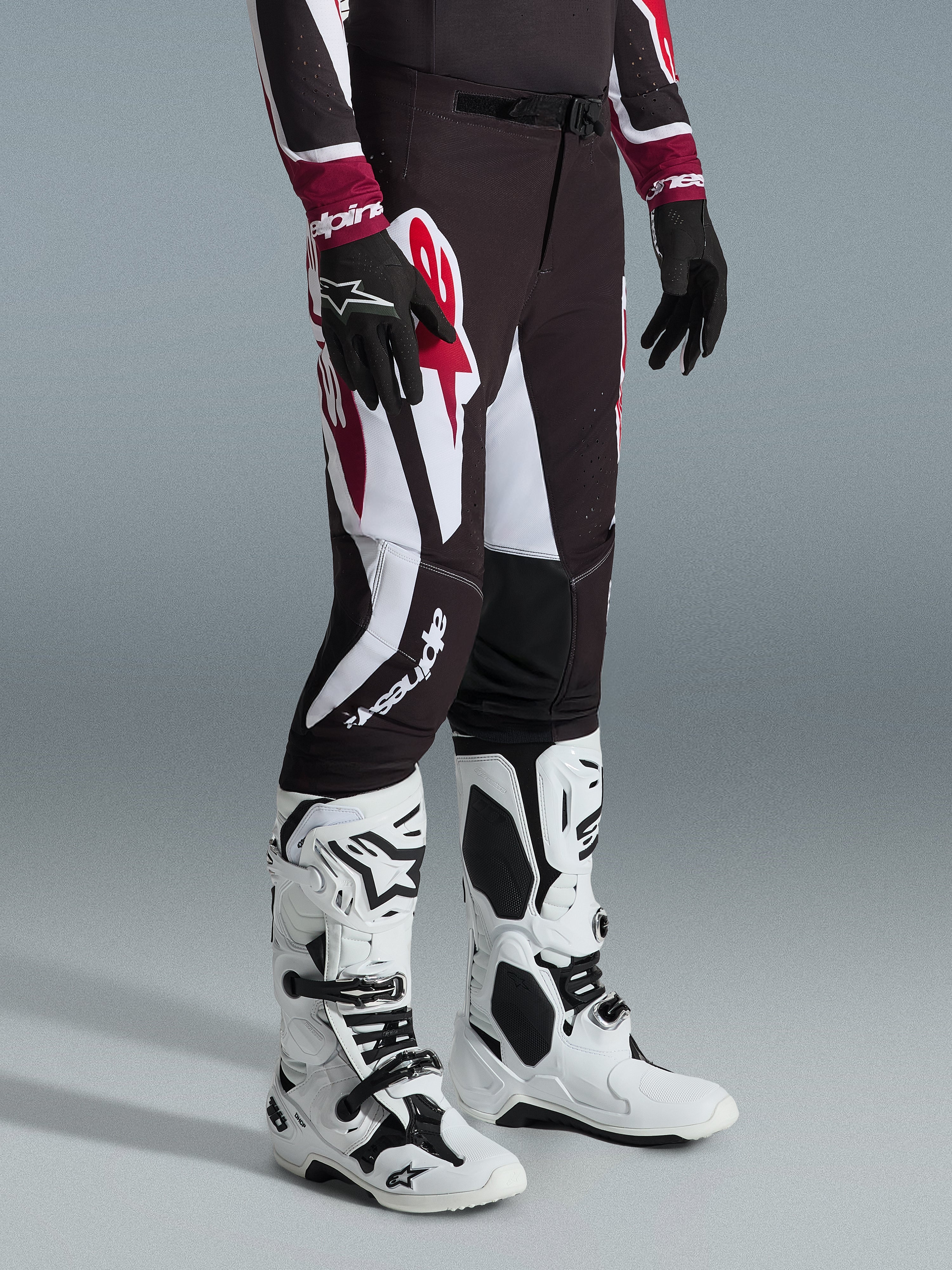 Alpinestars 2026 Supertech AFD Vista Pants, Motocross Pants, Black Red and White, worn with white and black motocross boots and black gloves, featuring large white and red graphic patterns, athletic race fit design