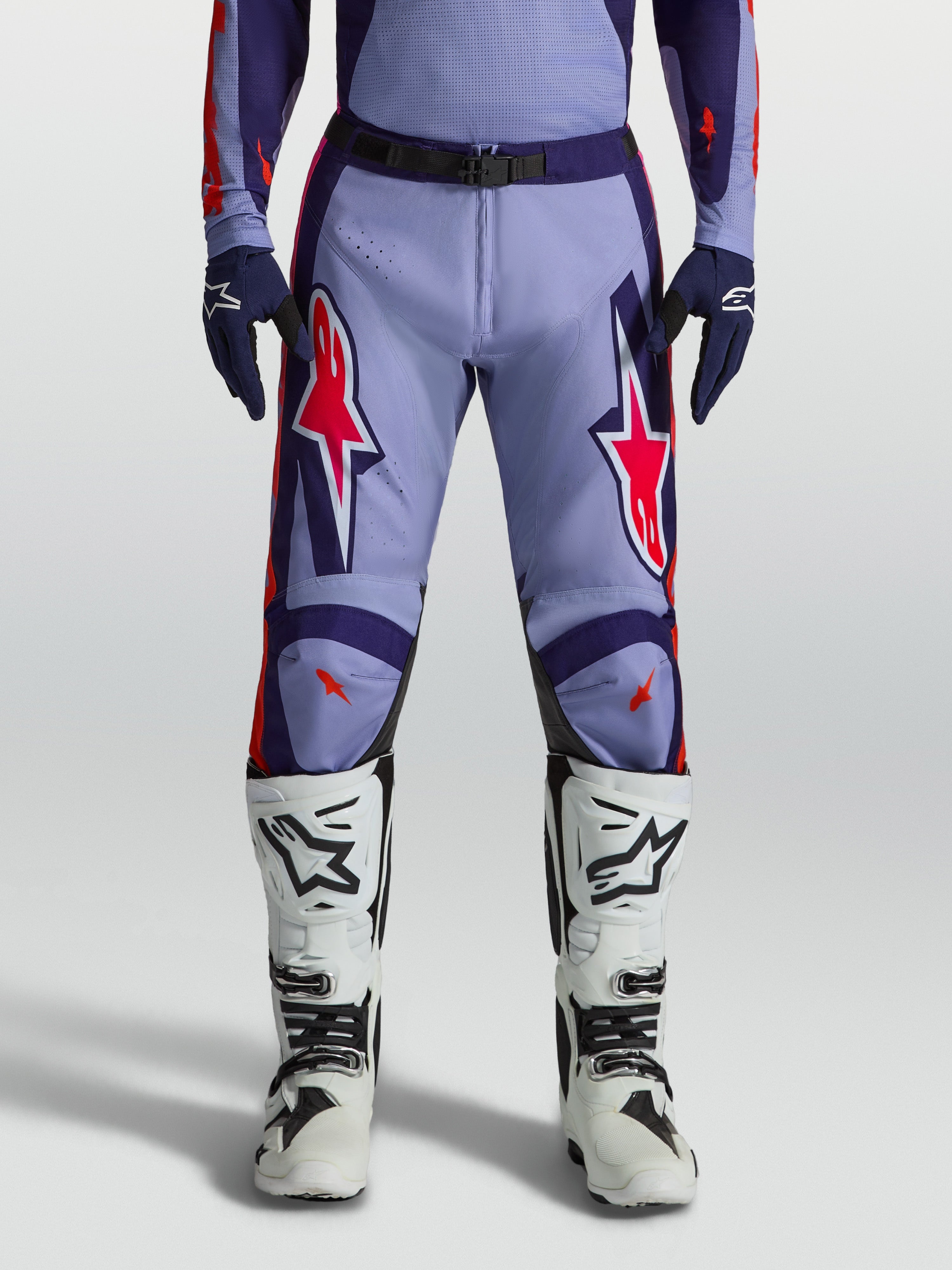 Alpinestars Racer Air Hunt Motocross Pants in light violet and deep purple with pink fluo accents, worn with white boots.