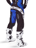 Alpinestars 2025 Techstar Dreem Pants, Motocross Pants, Black and Blue, rear view featuring bold white Alpinestars branding on the seat, worn with white and black motocross boots and matching blue jersey, athletic fit for off-road racing