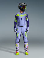 Alpinestars 2026 Supertech Scenz Gear Set, Motocross Racing Outfit, Light Purple and Neon Yellow-Green, full protective gear including black helmet with purple accents, jersey with bold neon yellow branding, matching pants with star graphics, and coordinated boots with pink highlights.