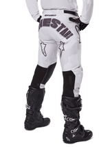 Alpinestars 2025 Racer Hollow Pants, Motocross Pants, Light Camo Brown, rear view of rider showing large branding on seat and black stretch panels on lower legs, paired with black Tech 7 boots