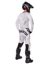 Alpinestars 2025 Racer Hollow Pants, Motocross Pants, Light Camo Brown and White, rear view showing bold black branding on the seat and star logos, worn with matching jersey, black boots, and black helmet for a complete off-road racing look