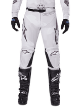 Alpinestars 2025 Racer Hollow Pants, Motocross Pants, Light Camo Brown, worn with black gloves and motocross boots, featuring a subtle camo pattern with black graphic prints and Astars logos, ergonomic design for performance off-road riding