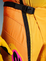 Alpinestars 2026 Techstar Nomur Pants, Motocross Pants, Orange Yellow Pink, close-up of the waist area featuring the SX2 magnetic buckle closure, black adjustment strap, and laser-cut ventilation perforations on durable ripstop material
