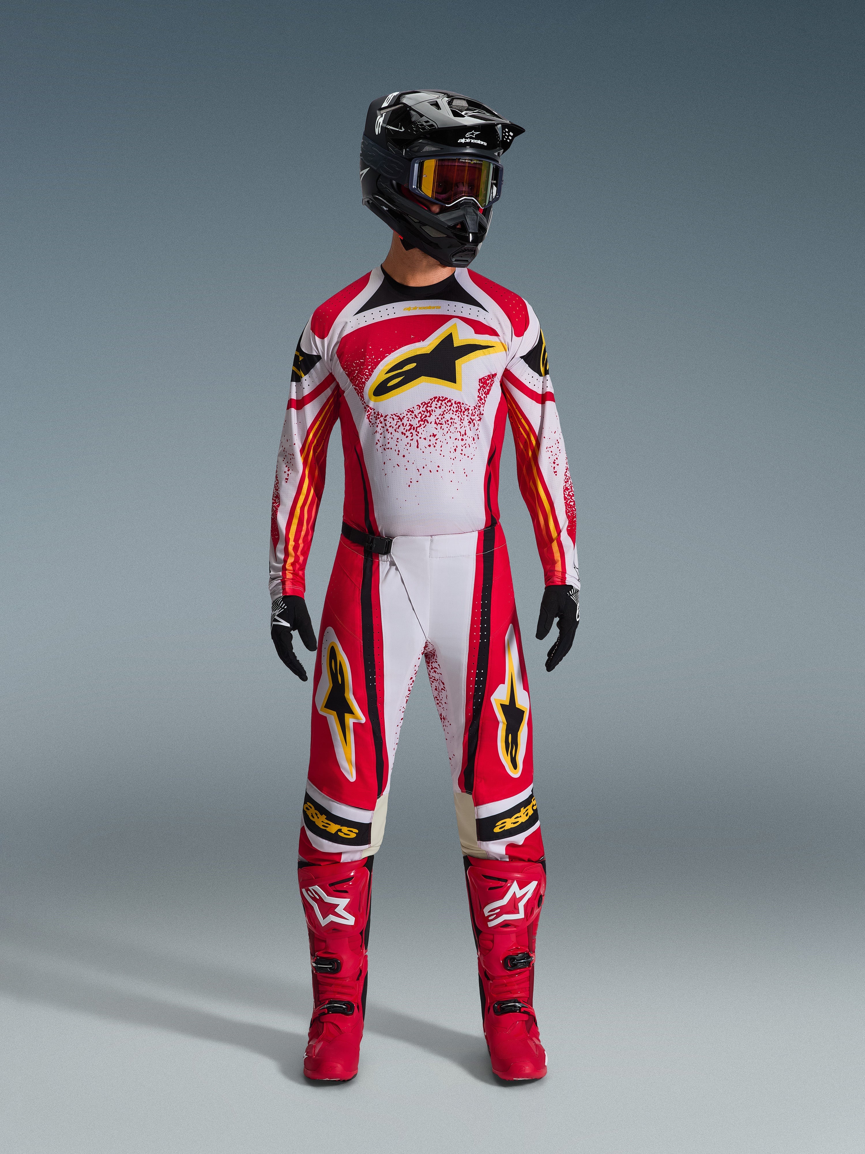 Alpinestars 2026 Techstar Nomur Gear Set, Motocross racing suit, Red white and black with yellow star logos, complete riding outfit featuring helmet, goggles, gloves, and boots, athletic race design for off-road performance
