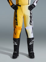 Alpinestars 2026 Fluid Apex Pants, Motocross Pants, Yellow and Black, split-color design with yellow and white panels, bold vertical 'astars' branding, worn with black motocross boots and gloves, performance gear for off-road riding