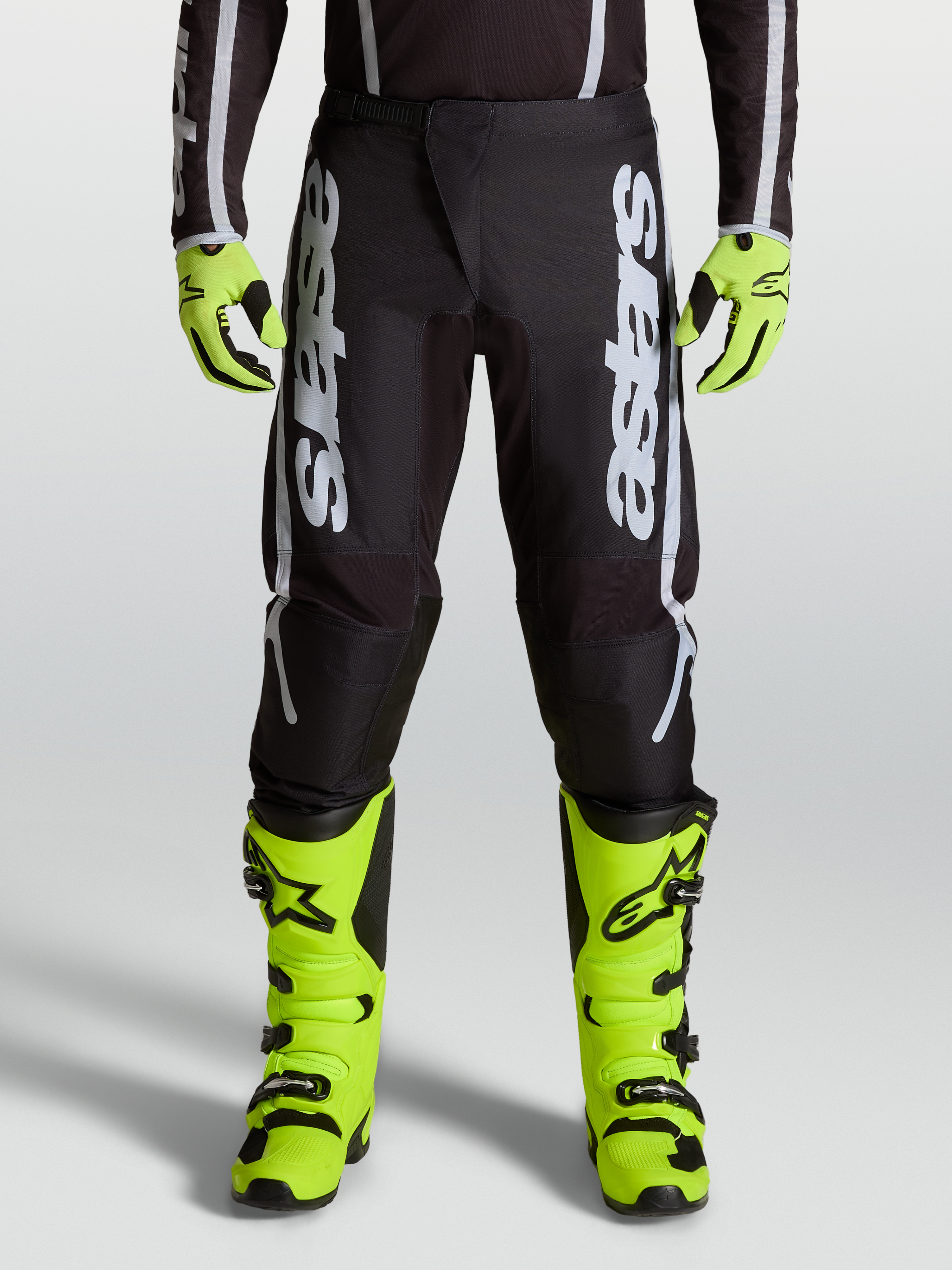 Alpinestars 2027 Fluid Apex V2 Men's Motocross Pants in Black and Silver, featuring ergonomic stretch panels on-model.