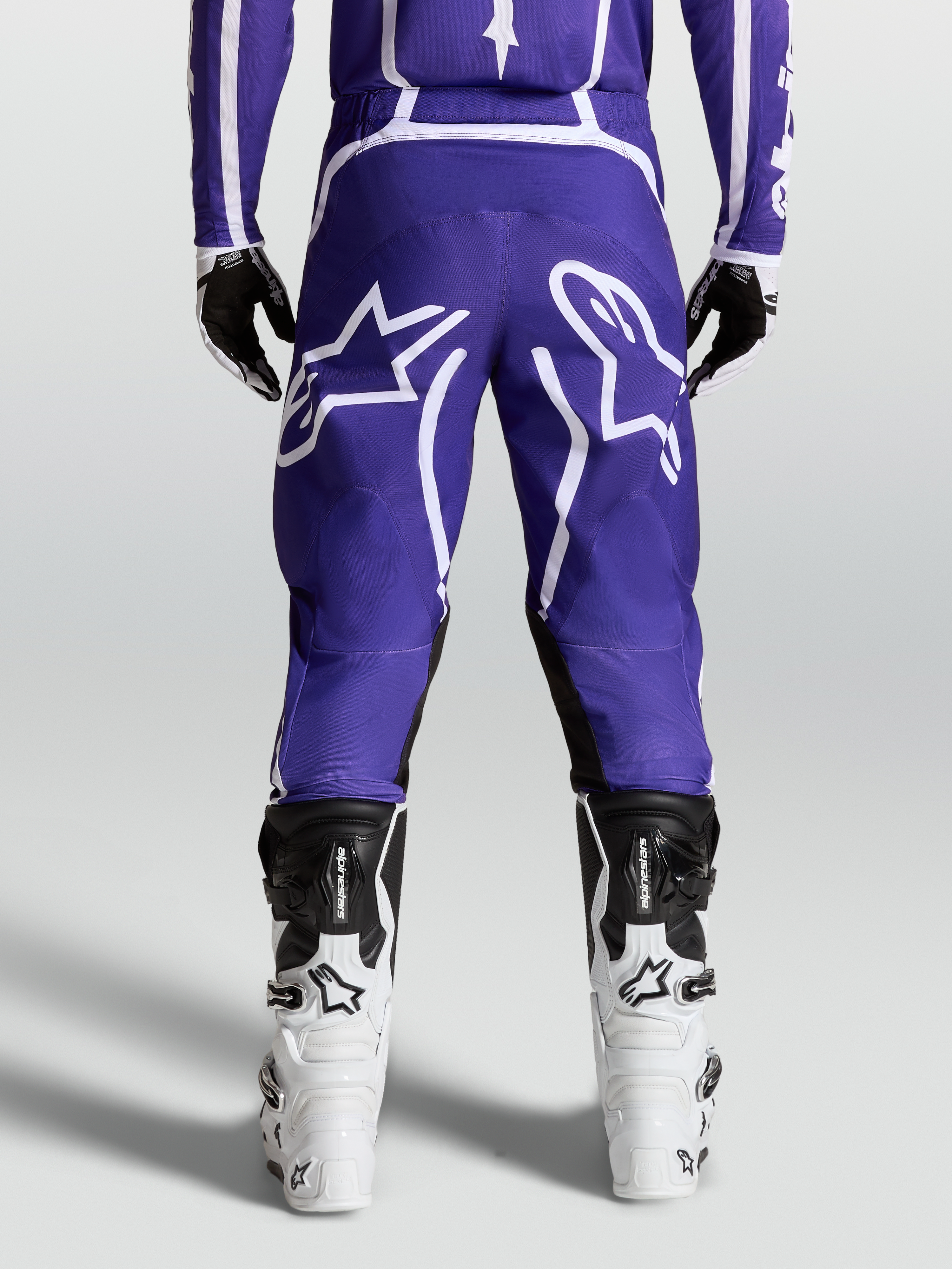 Alpinestars Fluid Apex V2 Pants, Men's Motocross and Off-Road Riding Pants, Deep Blue and White, durable 600D polyfabric and pre-curved leg design shown from the rear on model with boots.