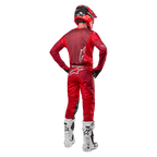 Alpinestars 2024 Racer Hoen Pants and matching jersey in Mars Red Burgundy, rear view of a motocross rider in full gear including a red helmet and white boots, showcasing the athletic fit and branding for off-road racing.