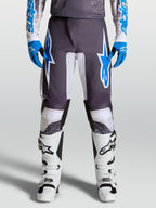 Alpinestars Fluid Drag Pants for motocross, Graystone and Ucla Blue, with pre-curved legs and ergonomic polyfabric protection.