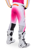 Alpinestars Supertech AFD MIG Limited Edition Motocross Pants, Pink and White, rear view featuring a vibrant pink gradient spray effect, orange logo on the back waist, paired with white and black Tech 10 boots, professional off-road racing apparel