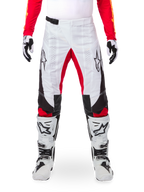 Alpinestars Limited Edition Techstar Deep Pants, Motocross Pants, Black White and High Red, worn with matching red jersey, white and black gloves and boots, featuring white front panels, red inner leg accents, black side panels, Alpinestars logos on thighs, and laser-perforated details for ventilation.