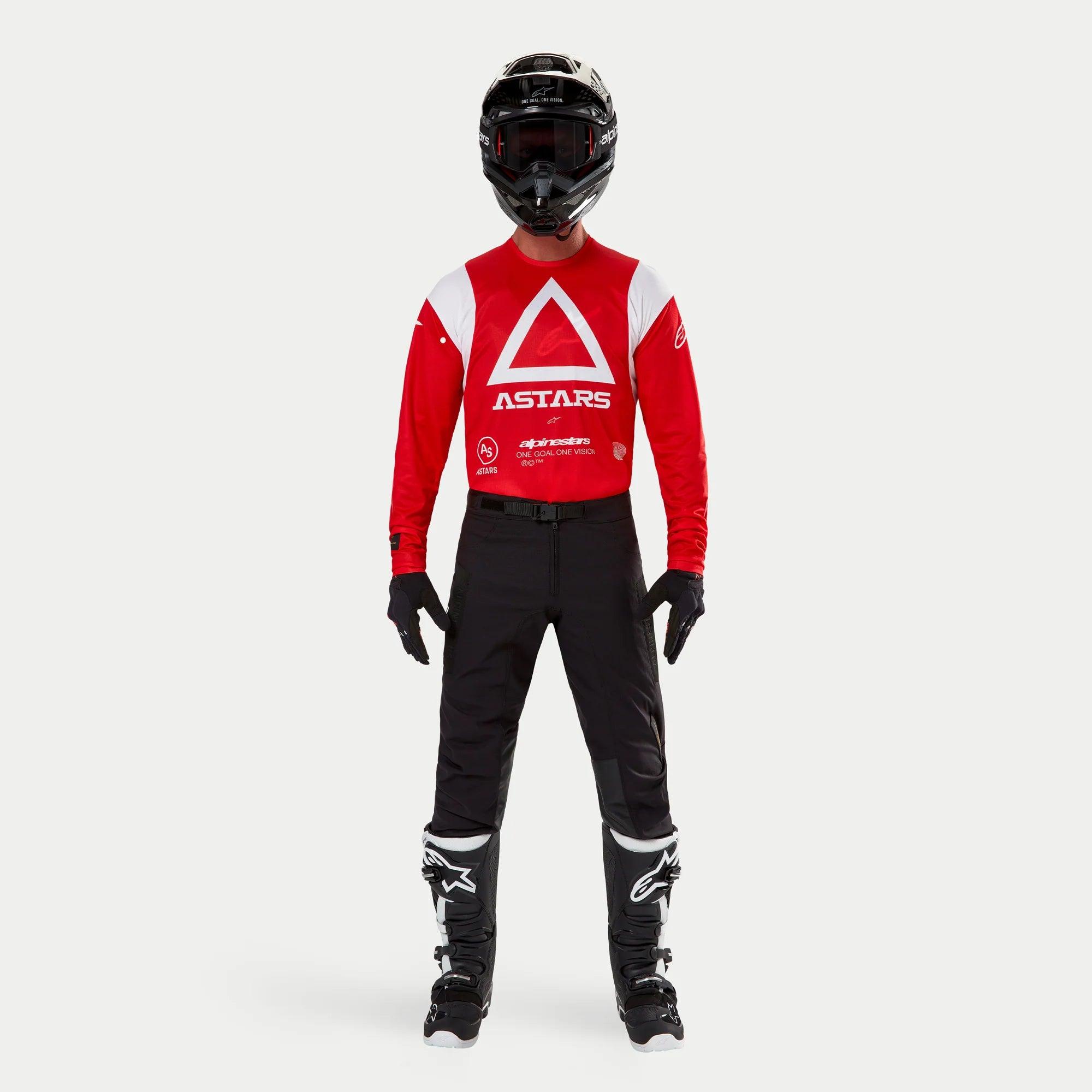 Alpinestars Techdura Pants, Enduro and Off-Road Pants, Black, worn with a red and white Astars long-sleeve jersey, black helmet, and black and white boots, featuring a rugged stretch polyamide construction and technical paneling for off-road riding.
