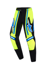 Alpinestars 2026 Youth Supertech Nomur Pants, Motocross Pants, Yellow Fluo, Dark Navy and Blue, featuring bold star logos on the outer thighs, black reinforced inner knee panels, and "astars" branding, athletic race fit for off-road performance