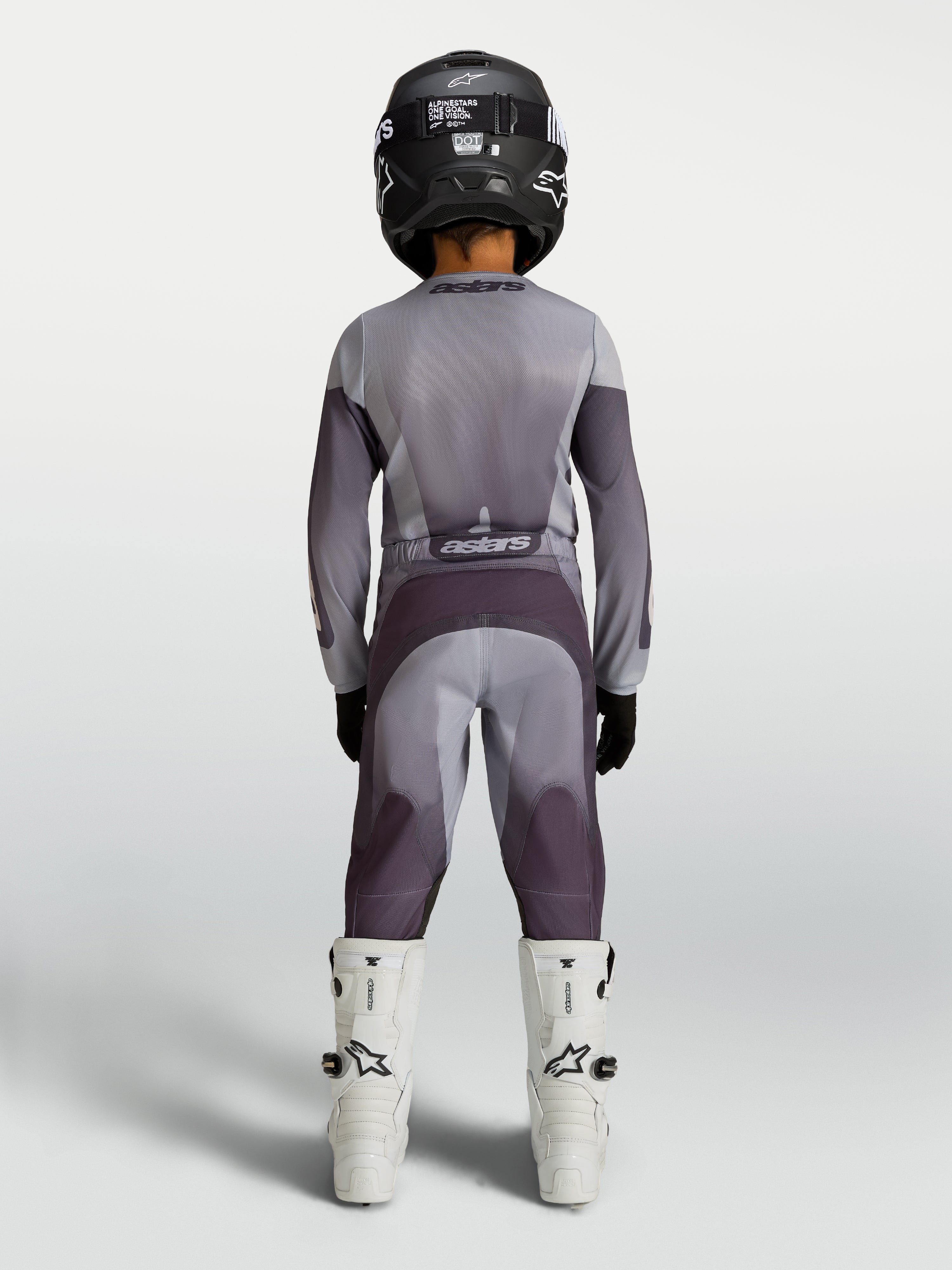 Alpinestars Youth Fluid Amber Pants in sand and gray, durable youth motocross pants shown from behind on a rider.