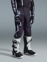 Alpinestars 2026 Youth Fluid Apex Pants, Motocross Pants, Black and Gray, featuring bold white branding, worn with a matching jersey, black and white gloves, and white and black boots, professional off-road racing gear
