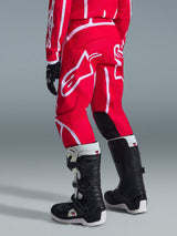 Alpinestars 2026 Youth Fluid Apex Pants, Motocross Pants, Red and White, rear view, featuring bold white branding and black inner knee panels, worn with matching jersey and black and white motocross boots
