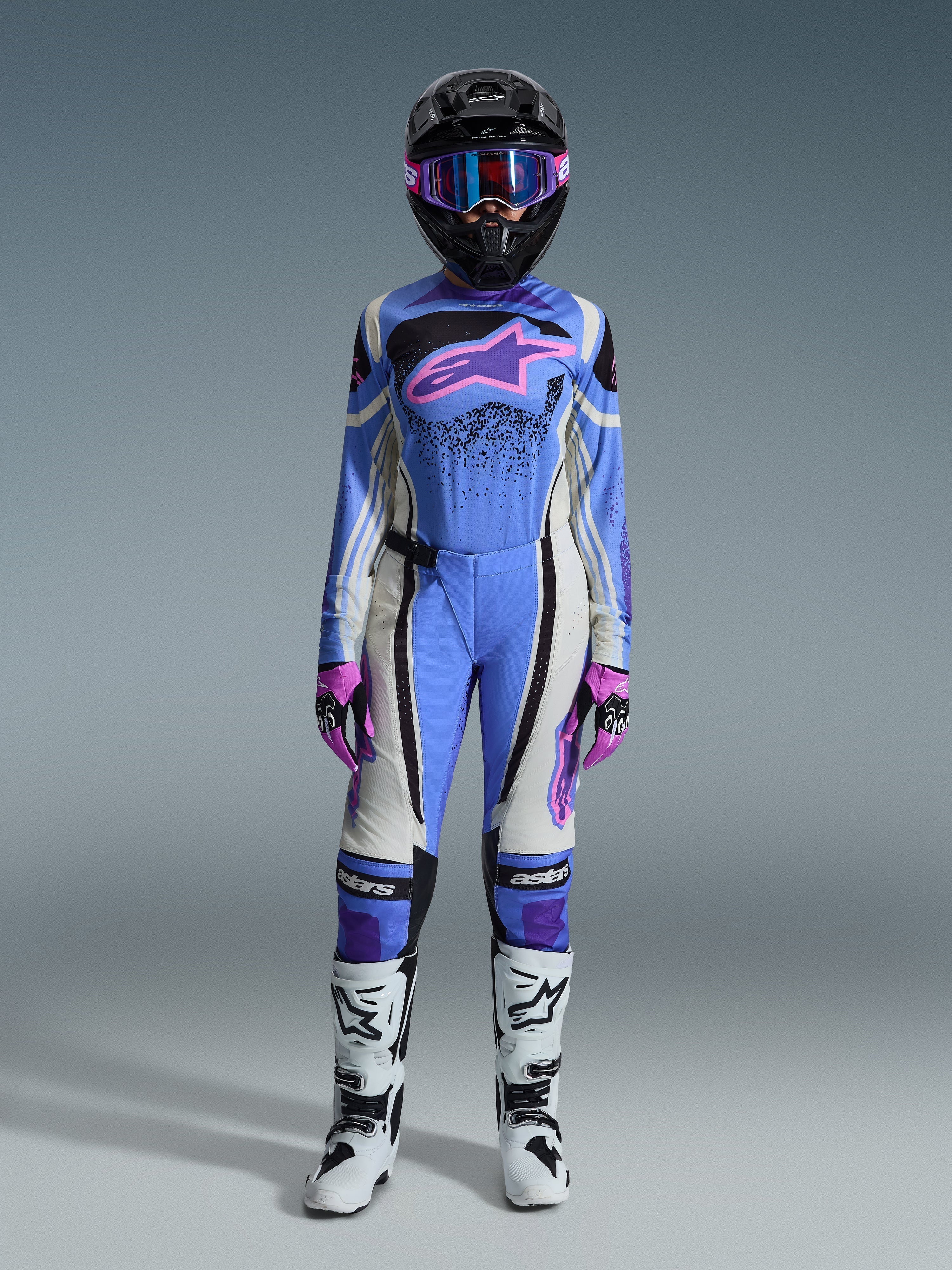 Alpinestars 2026 Woman Stella Techstar Nomur Gear Set, Motocross Racing Gear, Light Blue, Off White, and Pink, featuring black helmet with pink goggles, jersey with pink star logo, matching pants, pink and black gloves, and white and black boots.
