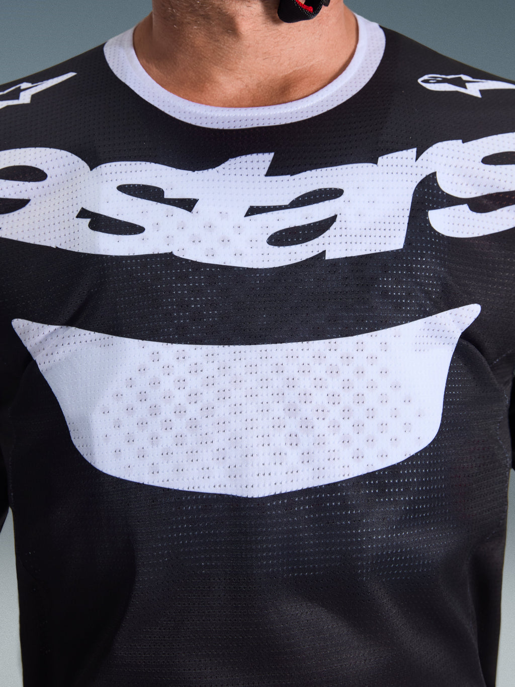 Alpinestars 2026 Racer Air Riway Jersey, Motocross Jersey, Black and White, close-up view of chest with large white logo, detailed mesh airflow fabric texture, technical breathable gear for off-road riding