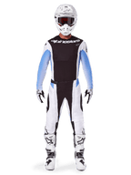 Motocross rider wearing complete Alpinestars 2025 Techstar Melt gear, black jersey with light blue gradient sleeves, white pants with black and blue accents, white helmet with black goggles, white and black boots and gloves, coordinated MX gear set for off-road racing