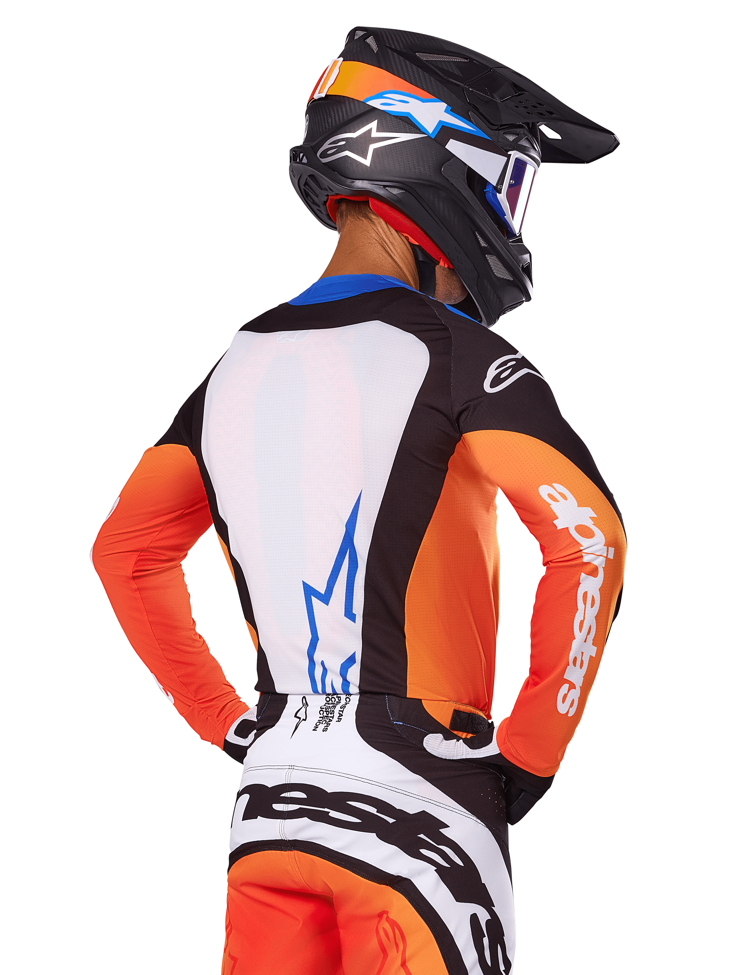 Motocross rider wearing Alpinestars 2025 Techstar Melt Jersey, Orange and Blue, rear view showing white back panel with blue logo, orange sleeves with white branding, matching motocross helmet and pants, professional racing gear.