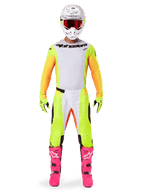 Alpinestars 2025 Techstar Melt Jersey, Motocross rider in full gear, white and yellow jersey with orange sleeves, matching yellow pants, bright pink boots, white helmet with red goggles, coordinated off-road racing kit